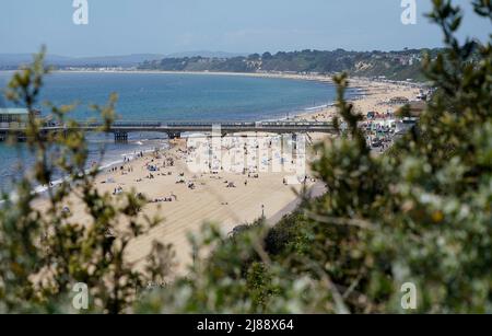 Die Menschen genießen das warme Wetter am Bournemouth Beach in Dorset. Die Temperaturen wärmen sich für das Wochenende auf, da die meisten Briten mit Sonnenschein rechnen können. Das Met Office warnte jedoch davor, dass auf einen sonnenverwöhnten Samstag, der ideal für ein Barbecue wäre, heftiger Regen und Gewitter folgen könnten. Bilddatum: Samstag, 14. Mai 2022. Stockfoto