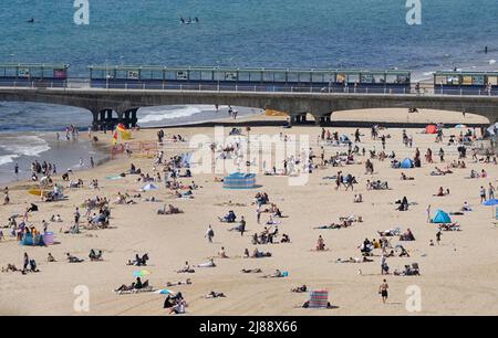 Die Menschen genießen das warme Wetter am Bournemouth Beach in Dorset. Die Temperaturen wärmen sich für das Wochenende auf, da die meisten Briten mit Sonnenschein rechnen können. Das Met Office warnte jedoch davor, dass auf einen sonnenverwöhnten Samstag, der ideal für ein Barbecue wäre, heftiger Regen und Gewitter folgen könnten. Bilddatum: Samstag, 14. Mai 2022. Stockfoto