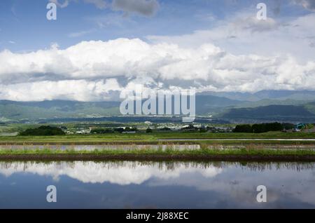 ina, nagano, japan, 2022/14/05 , Reisfelder in Ina, Nagano, im Frühling, während der Überflutung der Felder, so dass sie wie ein Spiegelbild aussehen Stockfoto