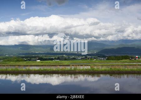 ina, nagano, japan, 2022/14/05 , Reisfelder in Ina, Nagano, im Frühling, während der Überflutung der Felder, so dass sie wie ein Spiegelbild aussehen Stockfoto