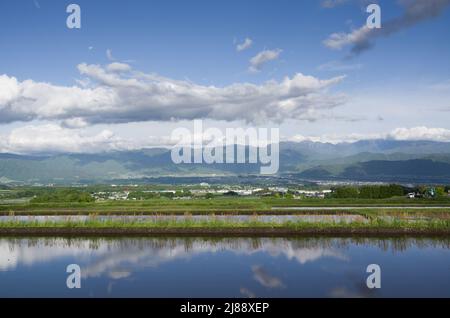 ina, nagano, japan, 2022/14/05 , Reisfelder in Ina, Nagano, im Frühling, während der Überflutung der Felder, so dass sie wie ein Spiegelbild aussehen Stockfoto