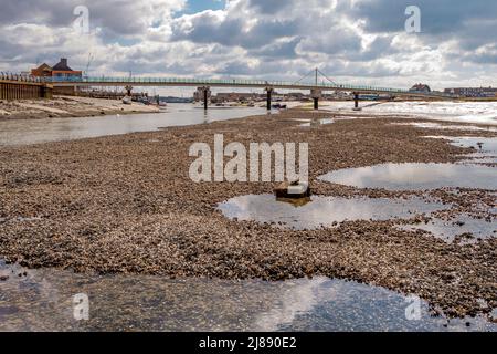 Der Fluss Adur bei Ebbe, mit Blick auf die Fußgängerbrücke und enthüllt ein ausgedehntes Flussbett und einen alten Ankerplatz - Shoreham-by-Sea, Sussex. Stockfoto