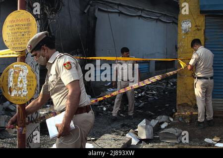 Neu-Delhi, Indien. 14.. Mai 2022. Polizeibeamte versiegeln einen Bereich auf dem Gelände eines Geschäftsgebäudes, der in Brand geraten ist. (Bild: © Karma Sonam Bhutia/ZUMA Press Wire) Bild: ZUMA Press, Inc./Alamy Live News Stockfoto