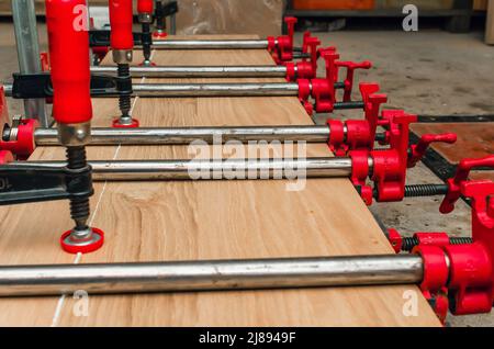 Nahaufnahme des Tischlerbefestigungsbretts mit Klammern. Schreinerei Stockfoto