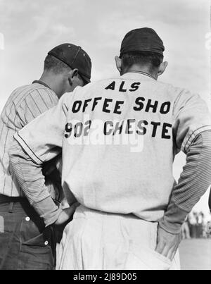 Ballspiel beobachten. Shafter-Lager. Kalifornien. [Spieler mit Hemd, der Al's Coffee Shop anwirbt]. Stockfoto