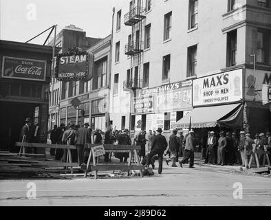 Salvation Army, San Francisco, Kalifornien. Allgemeine Sicht auf Armee und Menschenmengen. [Schilder: 'Danger - Street Closed; Pause...Drink Coca-Cola; Steam Welcome here; Okanes importierte Whiskys - Bourbon und Rye - Brandies - Weine vom Fass - Rainier Beer; Hauptquartier für Union Men - Wir verkaufen alles, was Männer tragen; Can't Bust 'EM Work Clothing; Max's Shop for Men - Famous for Gloves']. Stockfoto