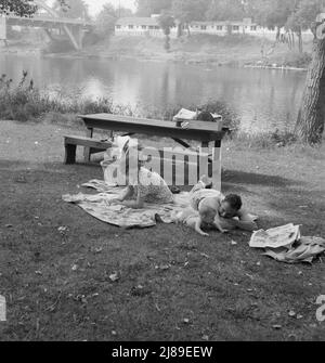 Oregon, Josephine County, Grants Pass. Sonntagspicknick im Park am Rogue River außerhalb der Stadt. [Baby kriecht auf selbstgemachter Steppdecke]. Stockfoto