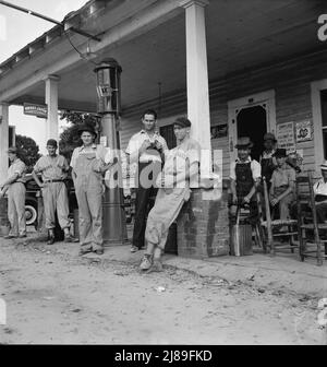 4. Juli, in der Nähe von Chapel Hill, North Carolina. Ländliche Tankstellen werden zu Gemeindezentren und allgemeinen Abladebädern. Die Männer in den Baseballanzanzügen gehören einer lokalen Mannschaft an, die in der Nähe ein Spiel spielt. Sie werden das Cedargrove-Team genannt. Stockfoto