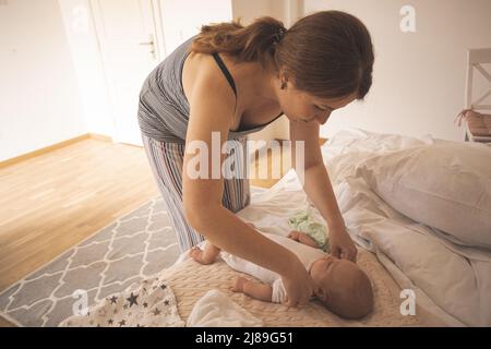 Frau, die mit ihrem Sohn interagiert, bevor sie sich umkleidet Stockfoto