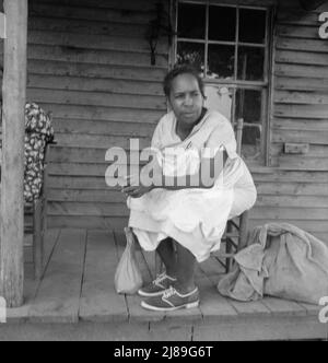 [Ohne Titel, möglicherweise verwandt mit: Mutter der Pächter-Familie und eines Freundes, die im Regen die Straße hinauf kommen und Gemüsesäcke vom Nachbarort nach Hause bringen. Person County, North Carolina. Abseits Des Highway 144]. Stockfoto