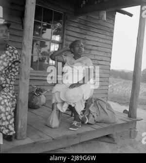 [Ohne Titel, möglicherweise verwandt mit: Mutter der Pächter-Familie und eines Freundes, die im Regen die Straße hinauf kommen und Gemüsesäcke vom Nachbarort nach Hause bringen. Person County, North Carolina. Abseits Des Highway 144]. Stockfoto