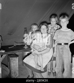 Sechsköpfige Familie im Zelt nach dem Abendessen. Kam zur Kartoffelernte, nachdem Vater von der WPA (Work Projects Administration) in Boise, Idaho, entlassen wurde. Das älteste Kind ist zwölf. Kleiner Junge hat Ruhr. Merrill, Klamath County, Oregon. In der mobilen Einheit der FSA (Farm Security Administration). Stockfoto