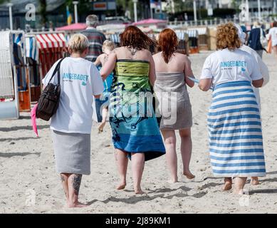 14. Mai 2022, Schleswig-Holstein, Travemünde: Vier Frauen laufen nach einem ersten Bad in der Ostsee bei Sonnenschein und 18 Grad Lufttemperatur am Strand entlang. Foto: Markus Scholz/dpa Stockfoto