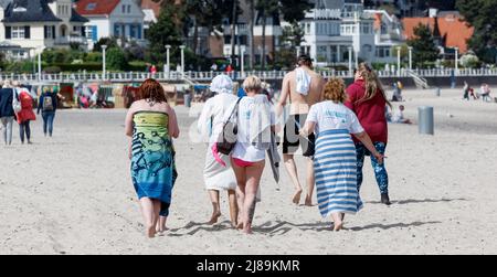14. Mai 2022, Schleswig-Holstein, Travemünde: Vier Frauen laufen nach einem ersten Bad in der Ostsee bei Sonnenschein und 18 Grad Lufttemperatur am Strand entlang. Foto: Markus Scholz/dpa Stockfoto