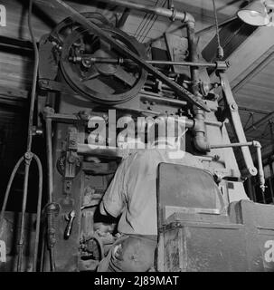 [Foto ohne Titel, möglicherweise verwandt mit: New Britain, Connecticut Eine Kernblasmaschine. Sand wird in den Kernkasten geblasen, während er sich auf einem Förderband von der Maschine wegbewegt]. Stockfoto