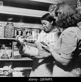 New Britain, Connecticut. Am 15. September 1942 wurde ein Kinderbetreuungszentrum für 30 Kinder im Alter von zwei bis fünf Jahren von Müttern eröffnet, die in der Kriegsindustrie tätig sind. Die Öffnungszeiten sind 6 Tage die Woche von 6:30 bis 6 Uhr. Frau Machmer und der Ernährungsberater überprüfen die Menge der Lebensmittel, die im Laufe des Monats verbraucht wurden, und führen eine allgemeine Bestandsaufnahme aller vorhandenen Vorräte durch. Stockfoto