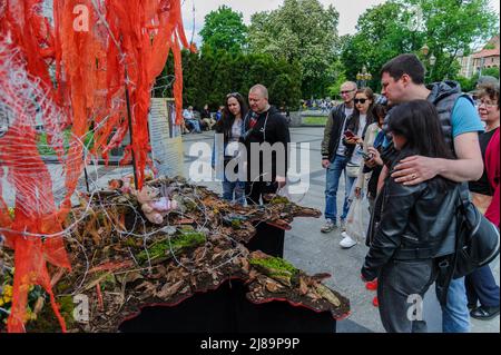 Lviv, Ukraine. 14.. Mai 2022. Die Menschen sahen sich das Kunstprojekt ''Screams of Souls'' an, das in Lemberg vorgestellt wurde. Große Karte der Ukraine mit blutigem Kinderspielzeug, zerstörten Häusern, Stacheldraht und Ähren von Weizen, die durch die verbrannte Erde sprießen. Die Autorin des Projekts ist Ulyana Datsishin. Russland marschierte am 24. Februar 2022 in die Ukraine ein und löste damit den größten militärischen Angriff in Europa seit dem Zweiten Weltkrieg aus (Bild: © Mykola Tys/SOPA Images via ZUMA Press Wire) Stockfoto