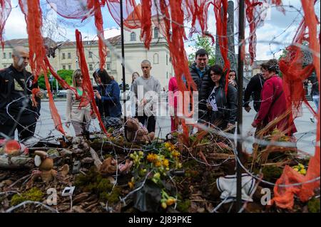 Lviv, Ukraine. 14.. Mai 2022. Die Menschen sahen sich das Kunstprojekt ''Screams of Souls'' an, das in Lemberg vorgestellt wurde. Große Karte der Ukraine mit blutigem Kinderspielzeug, zerstörten Häusern, Stacheldraht und Ähren von Weizen, die durch die verbrannte Erde sprießen. Die Autorin des Projekts ist Ulyana Datsishin. Russland marschierte am 24. Februar 2022 in die Ukraine ein und löste damit den größten militärischen Angriff in Europa seit dem Zweiten Weltkrieg aus (Bild: © Mykola Tys/SOPA Images via ZUMA Press Wire) Stockfoto