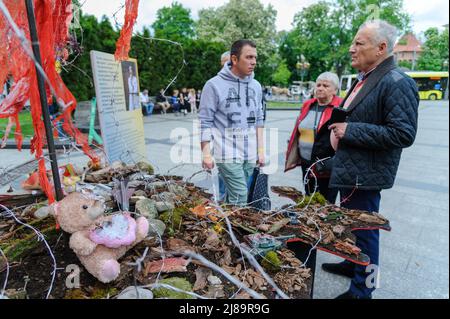 Lviv, Ukraine. 14.. Mai 2022. Die Menschen sahen sich das Kunstprojekt ''Screams of Souls'' an, das in Lemberg vorgestellt wurde. Große Karte der Ukraine mit blutigem Kinderspielzeug, zerstörten Häusern, Stacheldraht und Ähren von Weizen, die durch die verbrannte Erde sprießen. Die Autorin des Projekts ist Ulyana Datsishin. Russland marschierte am 24. Februar 2022 in die Ukraine ein und löste damit den größten militärischen Angriff in Europa seit dem Zweiten Weltkrieg aus (Bild: © Mykola Tys/SOPA Images via ZUMA Press Wire) Stockfoto