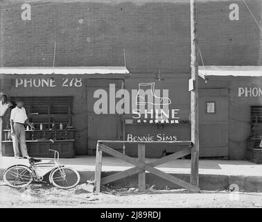 Schuhputzstand, Südosten der USA [Schild: „Shine - Bennie Sims“. Auf dem Fahrrad: City Shine Parlor']. Stockfoto