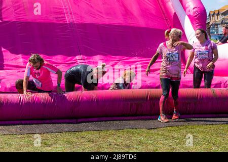 Köter Park, Poole, Dorset, Großbritannien. 14. Mai 2022. Schöner warmer sonniger Tag für Race for Life Poole Pretty Muddy, mit hunderten von vielen in Pink gekleideten Menschen, die sich dem Kampf gegen Krebs anschließen und Geld für Cancer Research UK sammeln, Hindernisse aushandeln und Spaß daran haben, sich sowohl beim Kinderrennen als auch bei Erwachsenen mit Schlamm zu bedecken. Quelle: Carolyn Jenkins/Alamy Live News Stockfoto