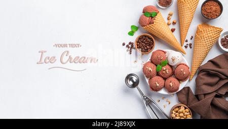 Eis, Waffelbecher, Schokolade, Kaffee und Nüsse auf hellem Hintergrund. Stockfoto