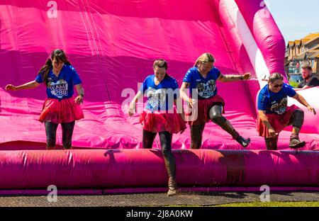 Köter Park, Poole, Dorset, Großbritannien. 14. Mai 2022. Schöner warmer sonniger Tag für Race for Life Poole Pretty Muddy, mit hunderten von vielen in Pink gekleideten Menschen, die sich dem Kampf gegen Krebs anschließen und Geld für Cancer Research UK sammeln, Hindernisse aushandeln und Spaß daran haben, sich sowohl beim Kinderrennen als auch bei Erwachsenen mit Schlamm zu bedecken. Quelle: Carolyn Jenkins/Alamy Live News Stockfoto