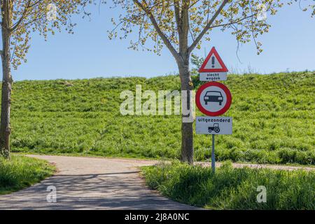 Einfahrt auf einen Landweg mit Verkehrszeichen: Ein verbotenes Auto, Warndreieck, Schilder auf Niederländisch: Slecht Weg bedeutet schlechte Straße und Uitgezonderd bedeutet e Stockfoto