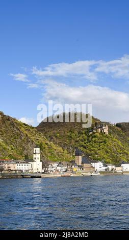 Loreleystadt St. Goarshousen, Deutschland - April 2022: Uferpromenade der Stadt am Rhein mit dem Schloss Katz auf dem Berg im Hintergrund Stockfoto