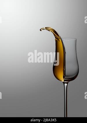 Das Getränk wird aus dem Glas verschüttet. Konzept des Themas Premium-Alkohol. Speicherplatz kopieren. Stockfoto