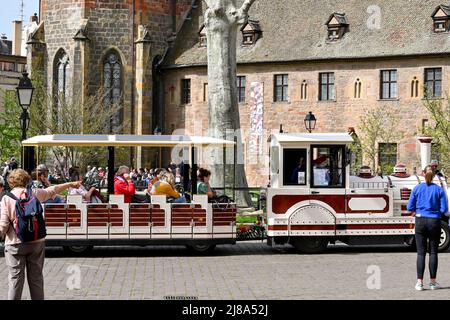 Colmar, Frankreich - 2022. April: Menschen, die in einem Touristenzug sitzen und sich auf eine Besichtigungstour durch die Stadt vorbereiten Stockfoto