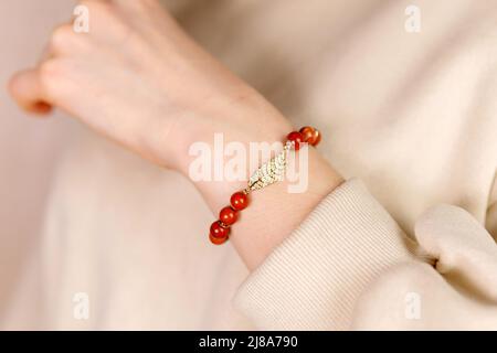 Jaspis-Armband. Armband aus Steinen auf der Hand aus Naturstein Jaspis. Selektiver Fokus Stockfoto