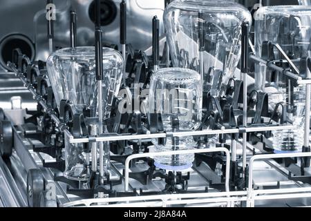 Die Glaskolbe, die Chemikalie- oder die Pharmaflasche in der Waschmaschine. Chemikalienbehälter. Glaswaren, Waschen, Reinigen und Sterilisieren Stockfoto