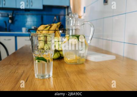 Frische Limonade im Glaskrug auf Holztisch. Sommergetränk eiskalte Limonade in Glas und Krug Stockfoto