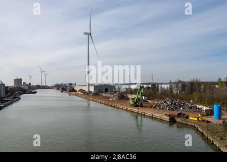 Genk, Limburg, Belgien - 04 12 2022 - Industrietätigkeit und ein von Windmühlen angetriebenes elektronisches Werk am Ufer des Albert-Kanals Stockfoto