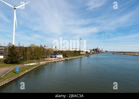 Genk, Limburg, Belgien - 04 12 2022 - Industrietätigkeit und ein von Windmühlen angetriebenes elektronisches Werk am Ufer des Albert-Kanals Stockfoto