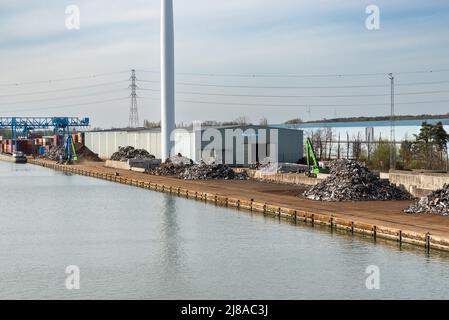 Genk, Limburg, Belgien - 04 12 2022 - Industrietätigkeit und ein von Windmühlen angetriebenes elektronisches Werk am Ufer des Albert-Kanals Stockfoto