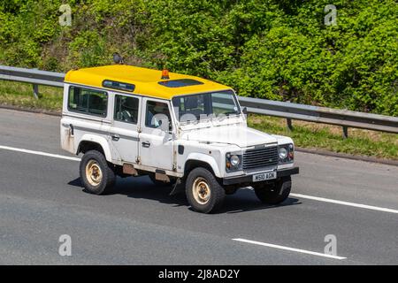 1995 90s Neunziger weiß-gelb 110 Land Rover Defender County Swtdi 2495cc Diesel Station Wagon; Anfahrt auf der Autobahn M6. Stockfoto