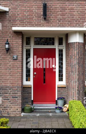 Echt, Limburg, Niederlande, 04 07 2022 - Rote Tür eines regulären Wohnhauses in der Reihe Stockfoto