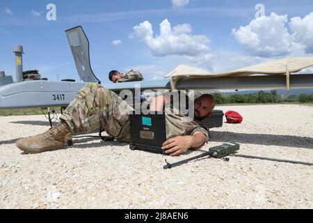 US Army Sgt. Jack Trapp, rechts, eine unbemannte Flugzeugsystemreparaturerin, die dem 7-17. Air Cavalry Squadron zugewiesen wurde, 1. die Air Cavalry Brigade führt Routinewartung auf einer RQ-7B V2 Shadow Drohne während des Übungsabwehrs auf dem Krivolak Trainingsgelände durch, 10. Mai 2022 in Negotino, Nord-Mazedonien. Stockfoto