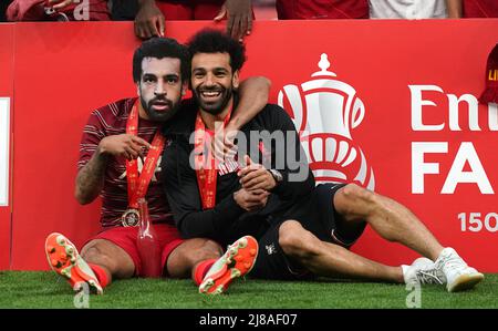 Der Liverpooler Thiago Alcantara (links) trägt eine Maske von Teamkollege Mohamed Salah, während er nach dem Finale des Emirates FA Cup im Wembley Stadium, London, neben ihm saß. Bilddatum: Samstag, 14. Mai 2022. Stockfoto