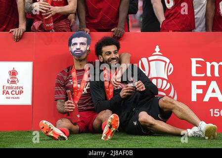 Der Liverpooler Thiago Alcantara (links) trägt eine Maske von Teamkollege Mohamed Salah, während er nach dem Finale des Emirates FA Cup im Wembley Stadium, London, neben ihm saß. Bilddatum: Samstag, 14. Mai 2022. Stockfoto