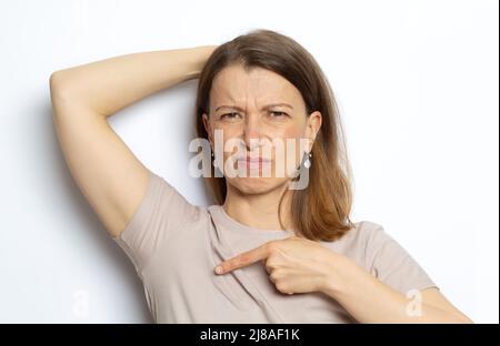 Unangenehmer Geruch von Schweiß unter dem Arm einer Frau. Stockfoto