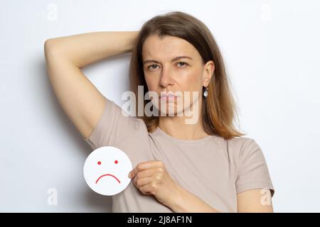 Unangenehmer Geruch von Schweiß unter dem Arm einer Frau. Stockfoto