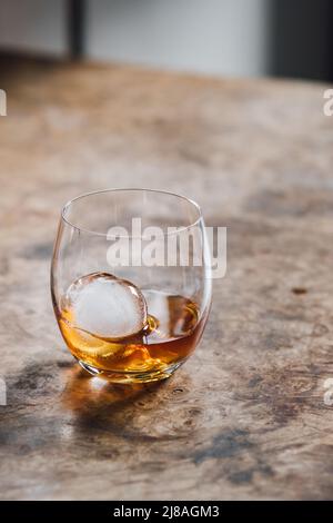 Whiskey aus Kristallglas mit Eiskugel Stockfoto
