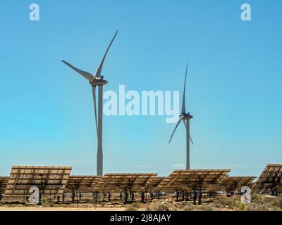 Moderne, umweltfreundliche Energieerzeugung, Stromerzeugung mit Windturbinen und großflächigen Solarzellen in einer windigen Region mit viel Stockfoto