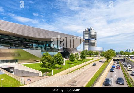 München - 2. Aug 2019: BMW Welt Gebäude und Autostraße in München, Bayern, Deutschland. World Headquarters Tower oder BMW Vierzylinder in der Ferne. Munchen c Stockfoto