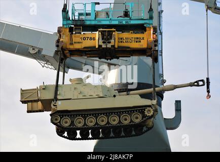 Eine Linie der US Army M109 Paladin selbstfahrenden Haubitze mit dem 1. Bataillon, 214. Field Artillery Regiment, 648. Manöver Enhancement Brigade, wird auf ein Frachtschiff angehoben, 10. Mai 2021, in Jacksonville, Florida. Die Rüstung wird zur Übung Afrikanischer Löwe nach Afrika verschifft. Stockfoto