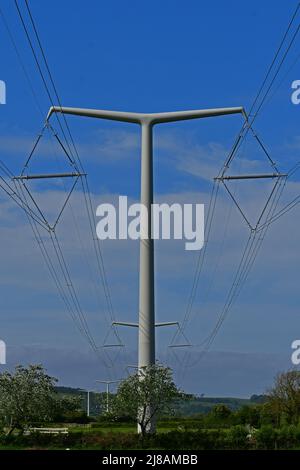 Bridgwater, Großbritannien. 13.. Mai 2022. An einem windigen und warmen, sonnigen Nachmittag werden die neu installierten ersten New Shape T-Pylonen mit Strom durch die grüne Landschaft von Rooksbridge in North Somerset gesehen, die vom National Grid zur Stromversorgung eingesetzt werden. Bildquelle: Robert Timoney/Alamy Live News Stockfoto