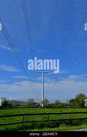 Bridgwater, Großbritannien. 13.. Mai 2022. An einem windigen und warmen, sonnigen Nachmittag werden die neu installierten ersten New Shape T-Pylonen mit Strom durch die grüne Landschaft von Rooksbridge in North Somerset gesehen, die vom National Grid zur Stromversorgung eingesetzt werden. Bildquelle: Robert Timoney/Alamy Live News Stockfoto